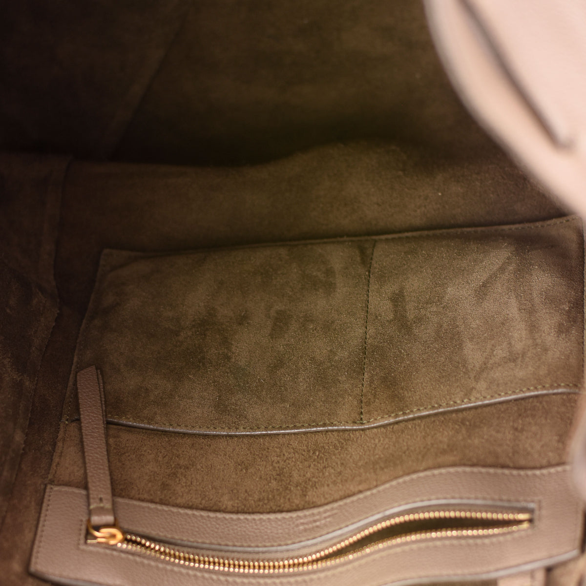 Interior of a brown suede lined luxury handbag with a gold zipper pocket. curated Pre-loved Luxury by Myluxe in Helsinki.
