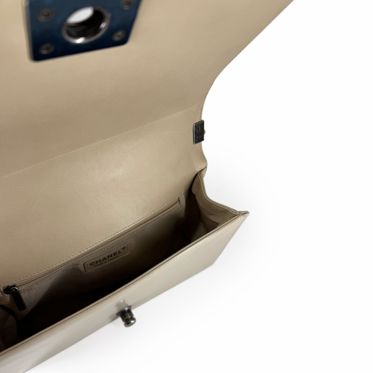 Interior of a beige Chanel leather flap bag with silver hardware, curated Pre-loved Luxury by Myluxe in Helsinki.