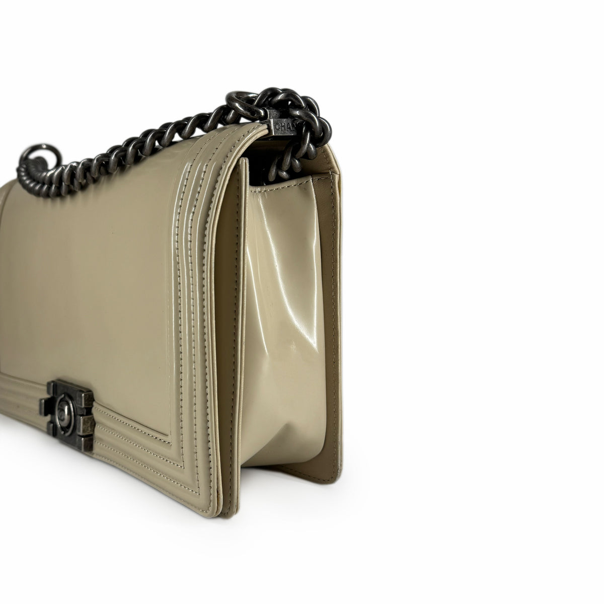 Beige patent leather shoulder bag with a dark metal chain strap, curated Pre-loved Luxury by Myluxe in Helsinki.