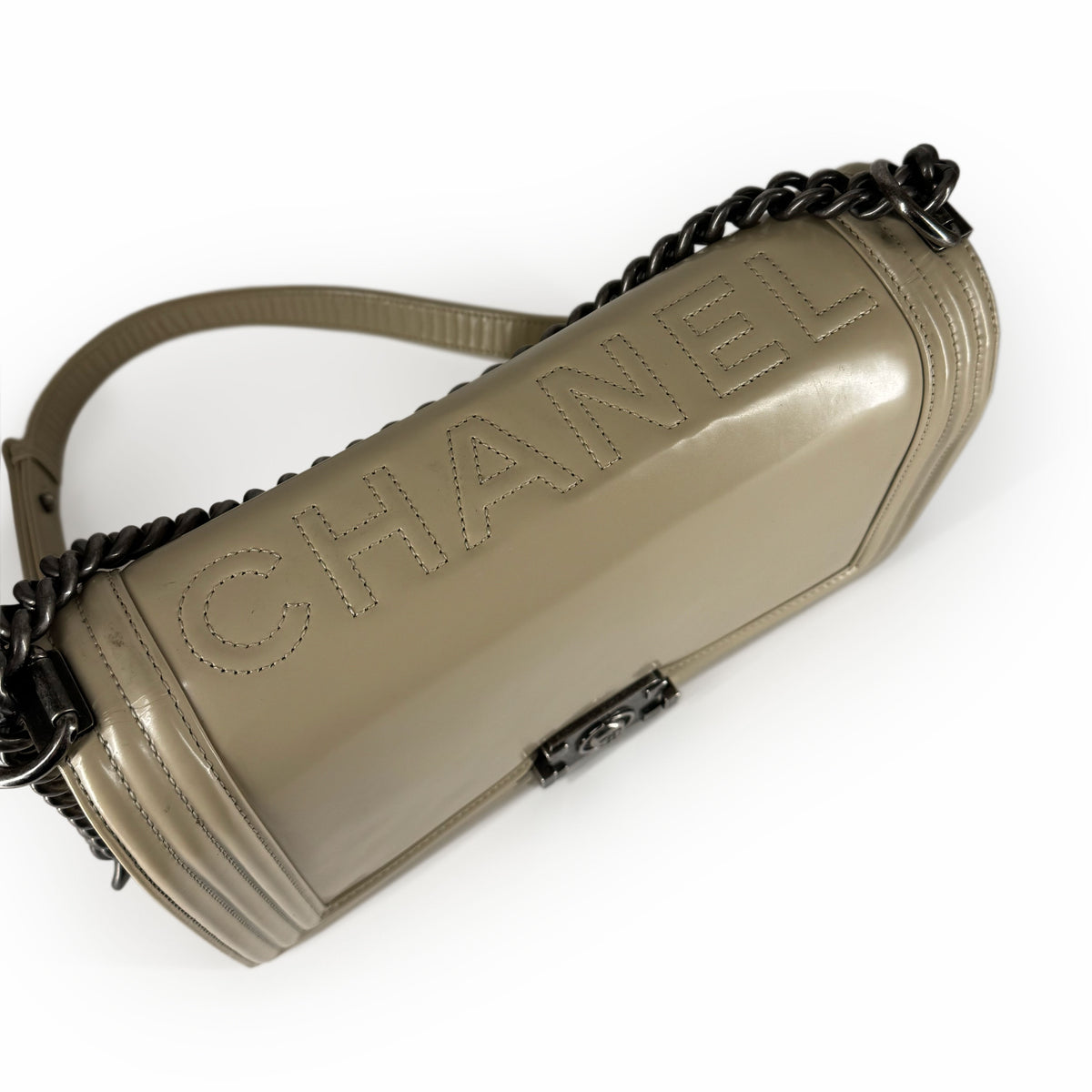 Chanel beige patent leather cylindrical shoulder bag with chain strap, curated Pre-loved Luxury by Myluxe in Helsinki.