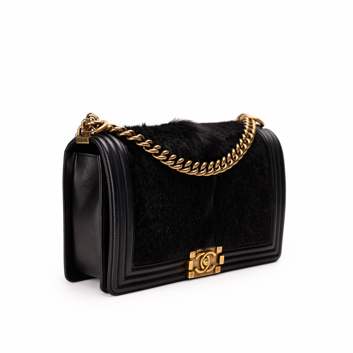 Black leather and faux fur Chanel flap bag with gold chain strap, curated Pre-loved Luxury by Myluxe in Helsinki.