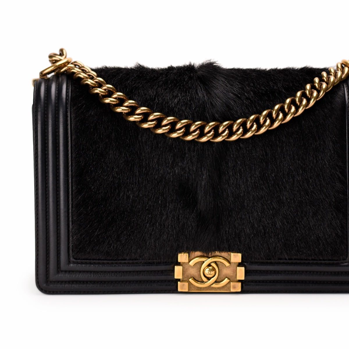 Black faux fur Chanel flap bag with gold chain strap and CC clasp, curated Pre-loved Luxury by Myluxe in Helsinki.