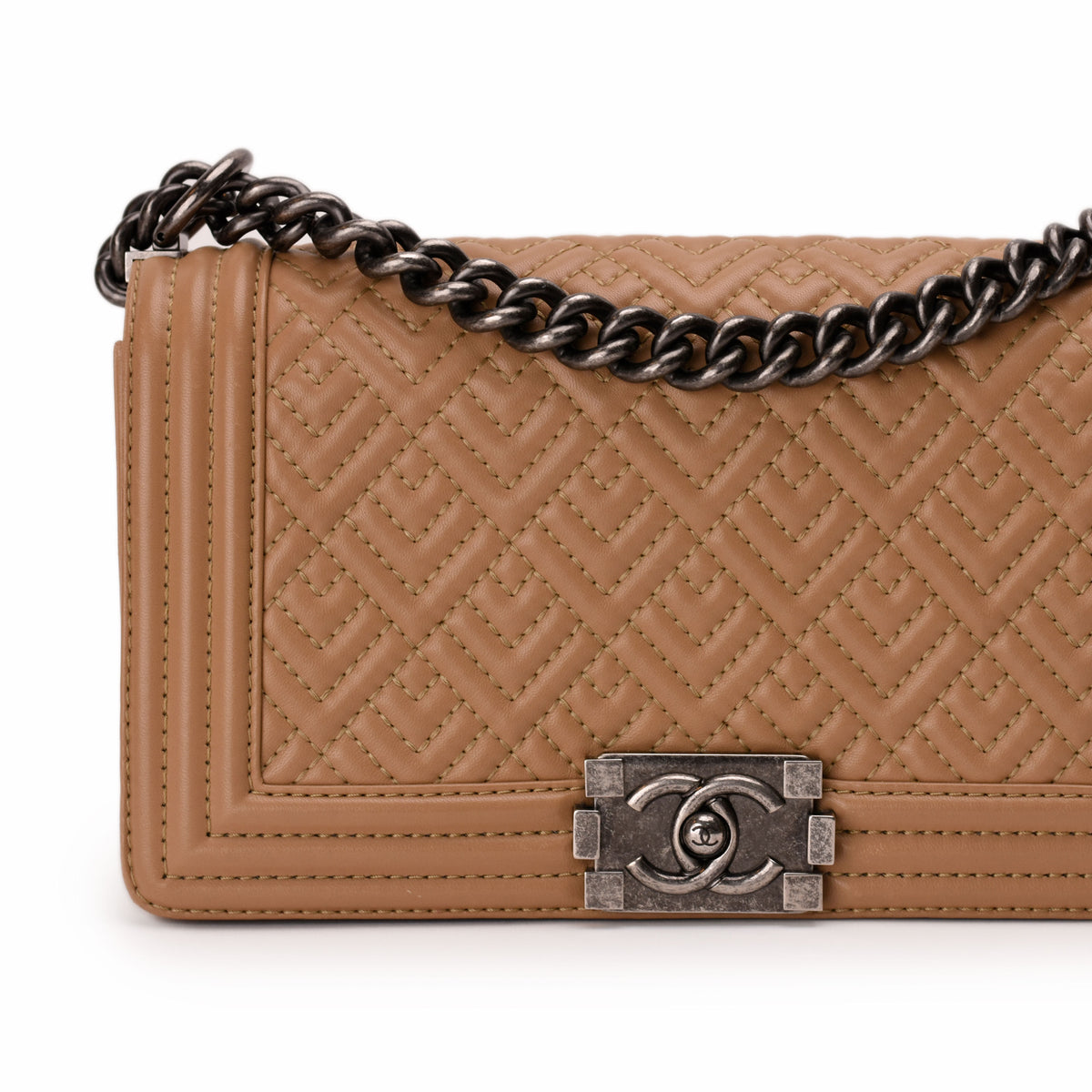 Tan quilted leather Chanel flap bag with dark metal chain strap, curated Pre-loved Luxury by Myluxe in Helsinki.