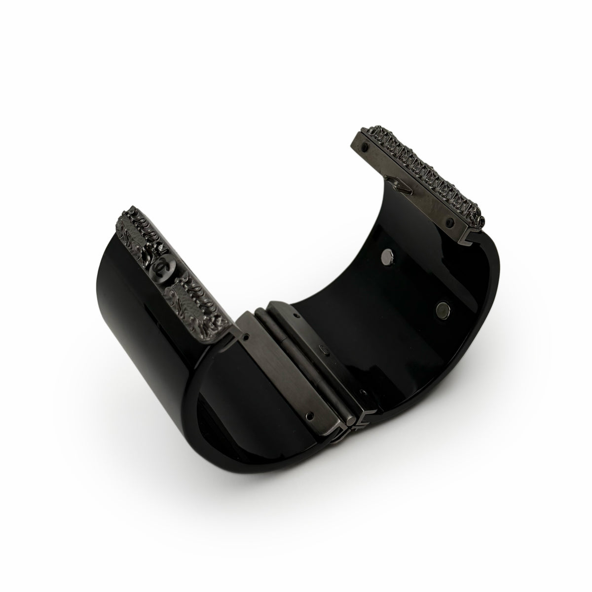 Black glossy wide cuff bracelet with ornate silver-tone textured metal edges, curated Pre-loved Luxury by Myluxe in Helsinki.