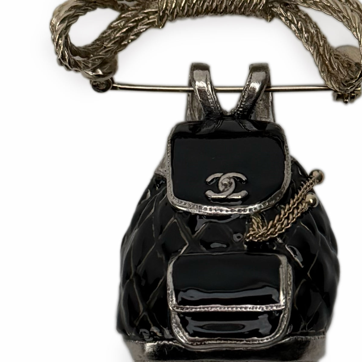 Chanel black enamel quilted handbag brooch with silver-tone hardware, curated Pre-loved Luxury by Myluxe in Helsinki.