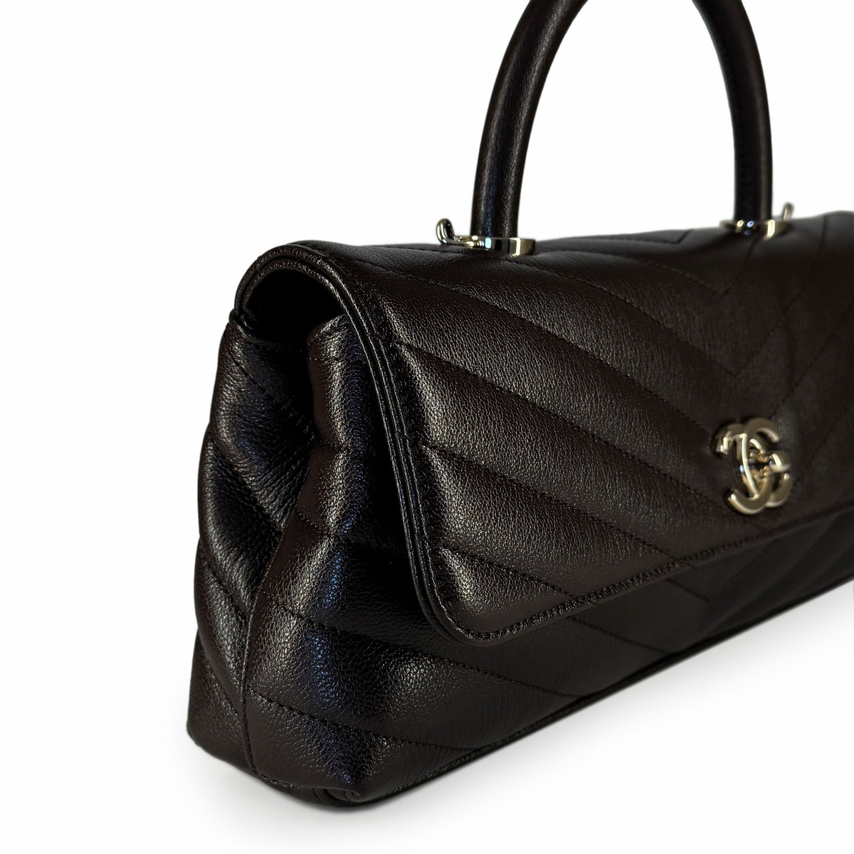 Dark brown quilted leather Chanel handbag with silver hardware, curated Pre-loved Luxury by Myluxe in Helsinki.
