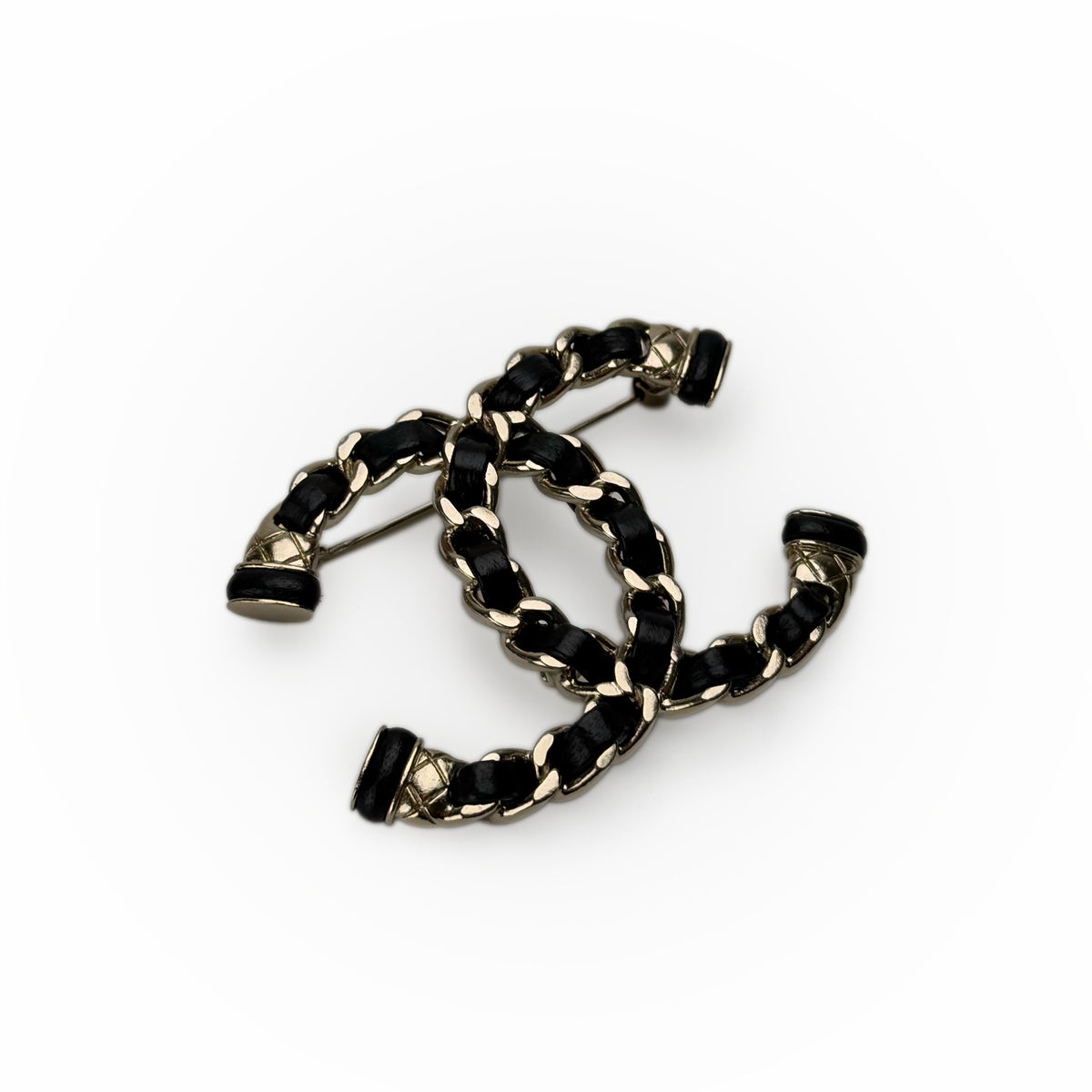 Chanel interlocking CC brooch in black leather and gold-tone metal, curated Pre-loved Luxury by Myluxe in Helsinki.