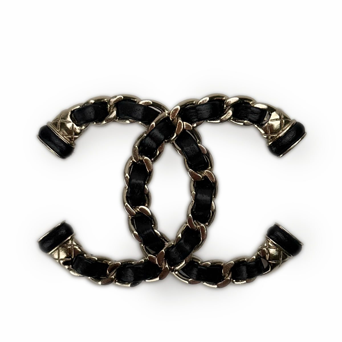 Interlocking black leather and gold-tone metal Chanel logo charm, curated Pre-loved Luxury by Myluxe in Helsinki.