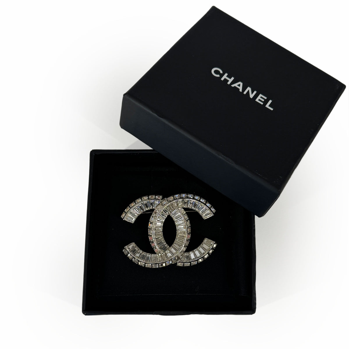 Chanel silver-tone crystal interlocking CC brooch in a black box, curated Pre-loved Luxury by Myluxe in Helsinki.