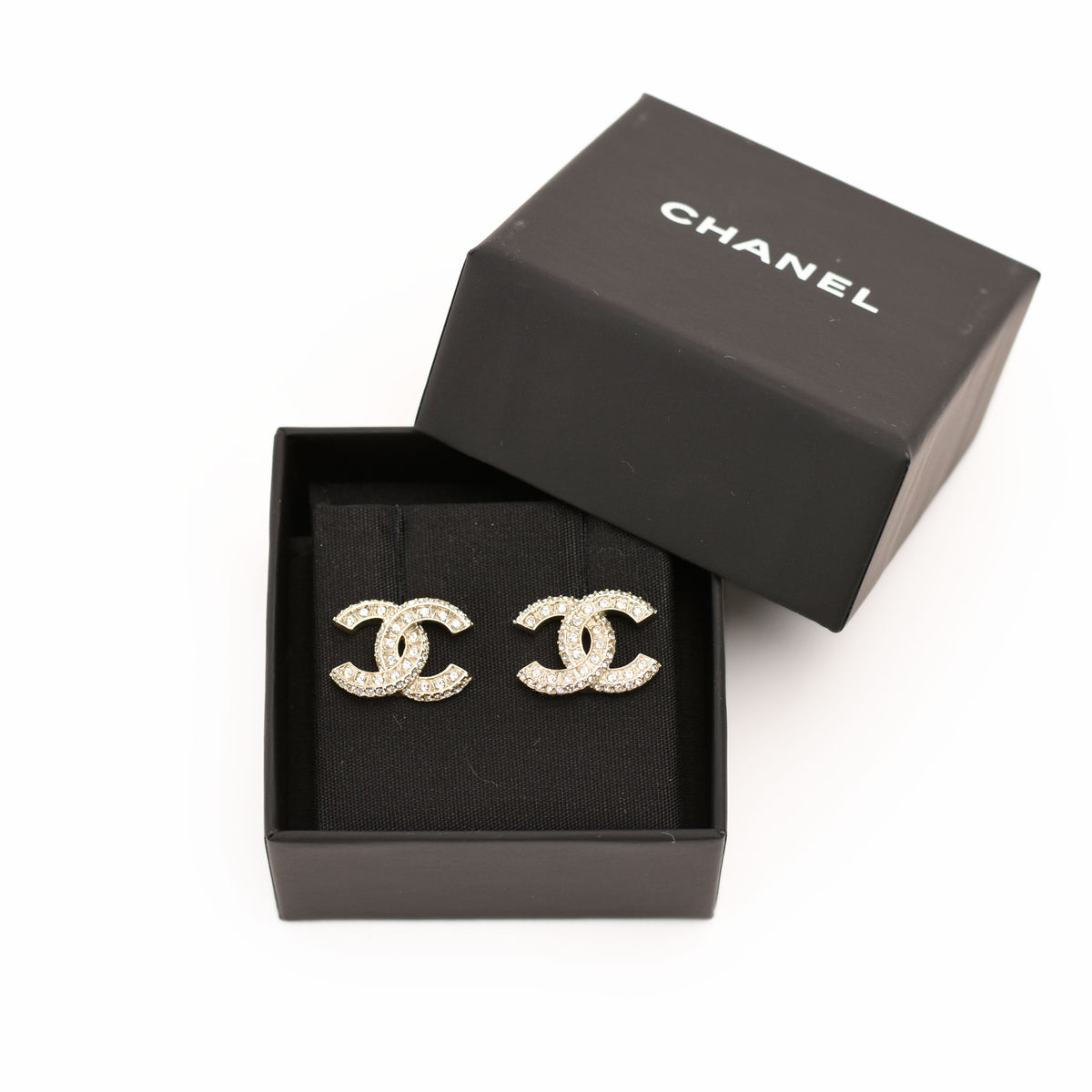 Chanel gold-tone CC logo earrings with crystals in a black box, curated Pre-loved Luxury by Myluxe in Helsinki.