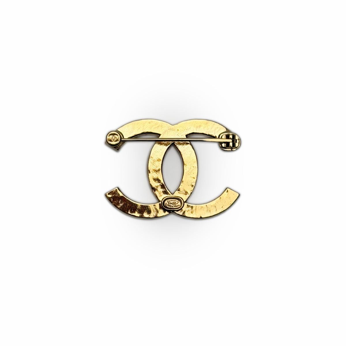Gold-tone interlocking CC logo brooch in textured metal, curated Pre-loved Luxury by Myluxe in Helsinki.