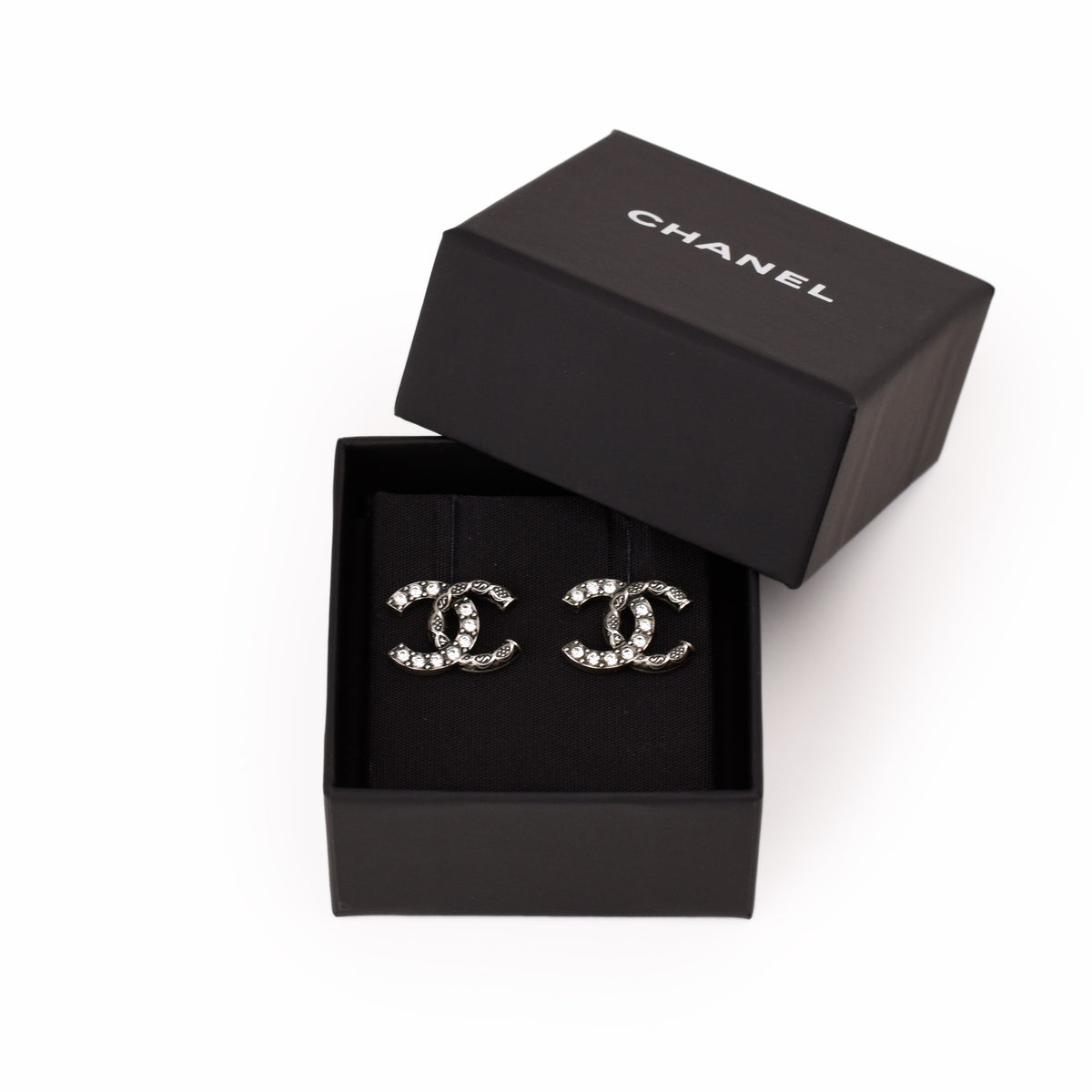 Chanel silver-tone interlocking C logo earrings with crystals in a black box, curated Pre-loved Luxury by Myluxe in Helsinki.