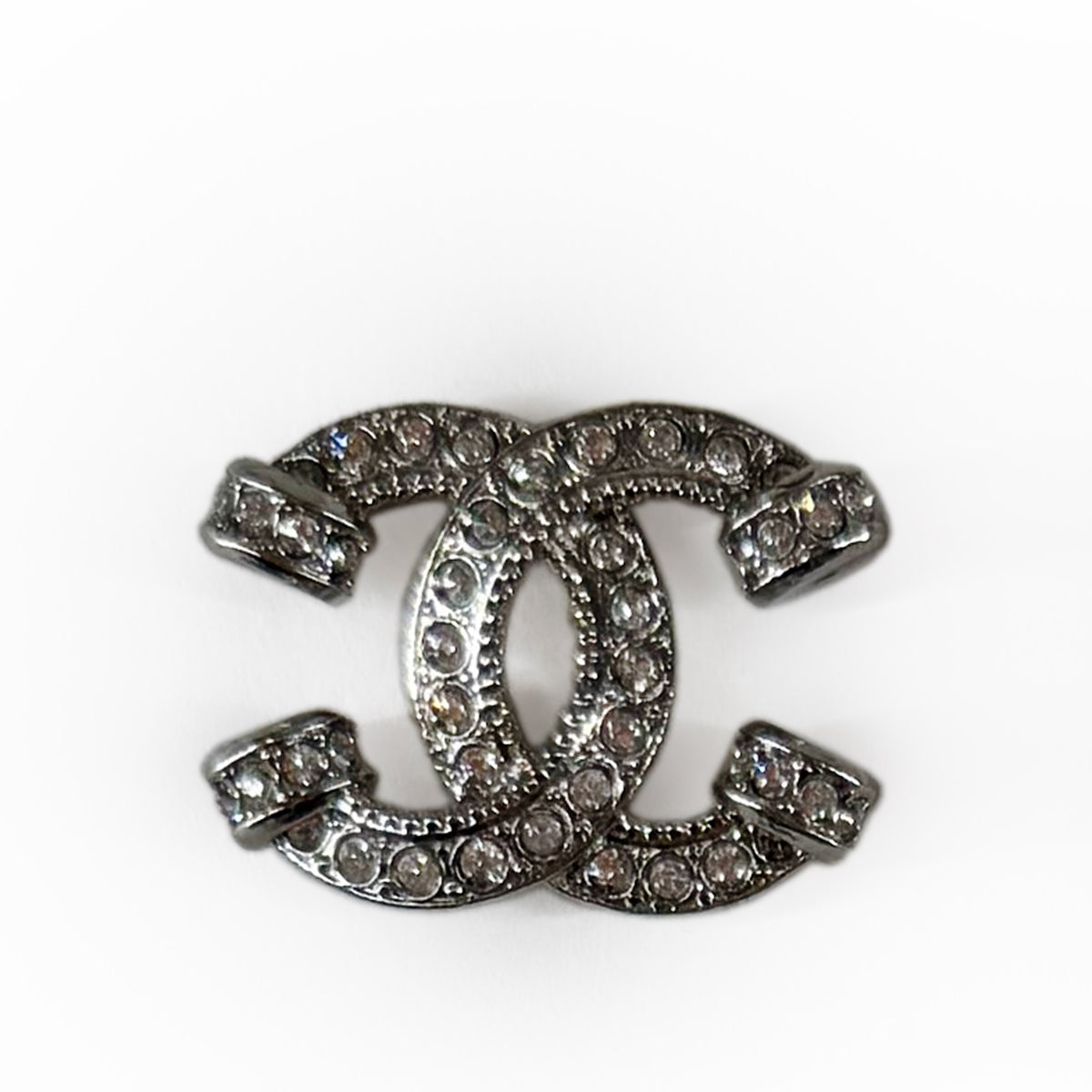 Silver-toned Chanel interlocking CC logo brooch encrusted with sparkling crystals, curated Pre-loved Luxury by Myluxe in Helsinki.