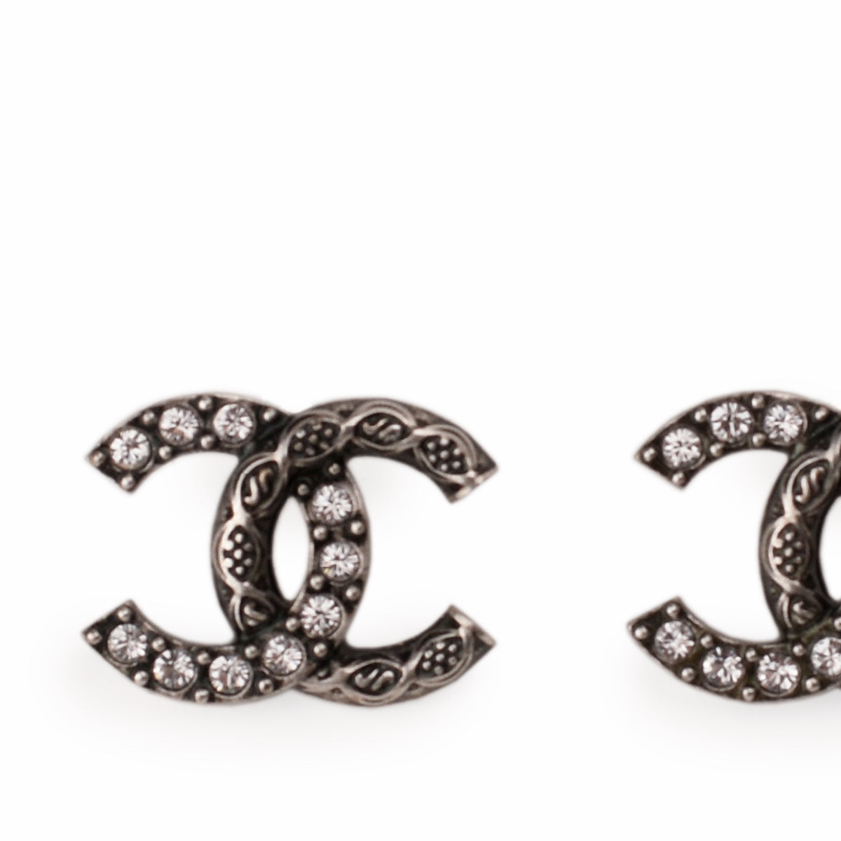 Detailed view of silver-tone Chanel interlocking CC earrings with crystal embellishments, curated Pre-loved Luxury by Myluxe in Helsinki.