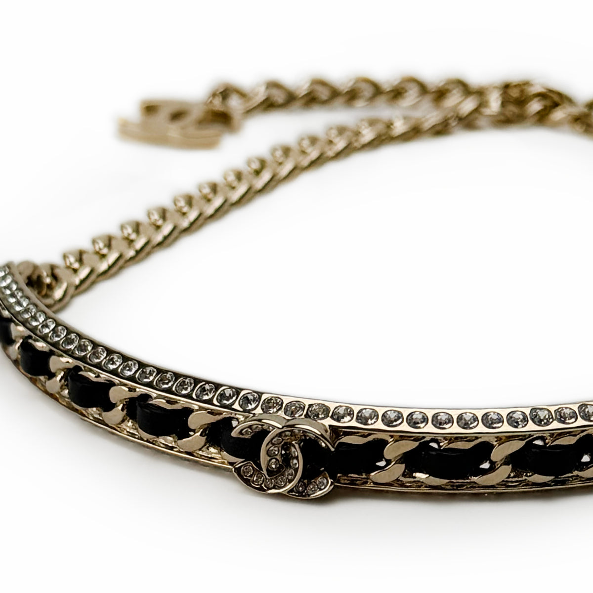Gold-tone Chanel chain bracelet with black leather inlay and crystal embellishments, curated Pre-loved Luxury by Myluxe in Helsinki.