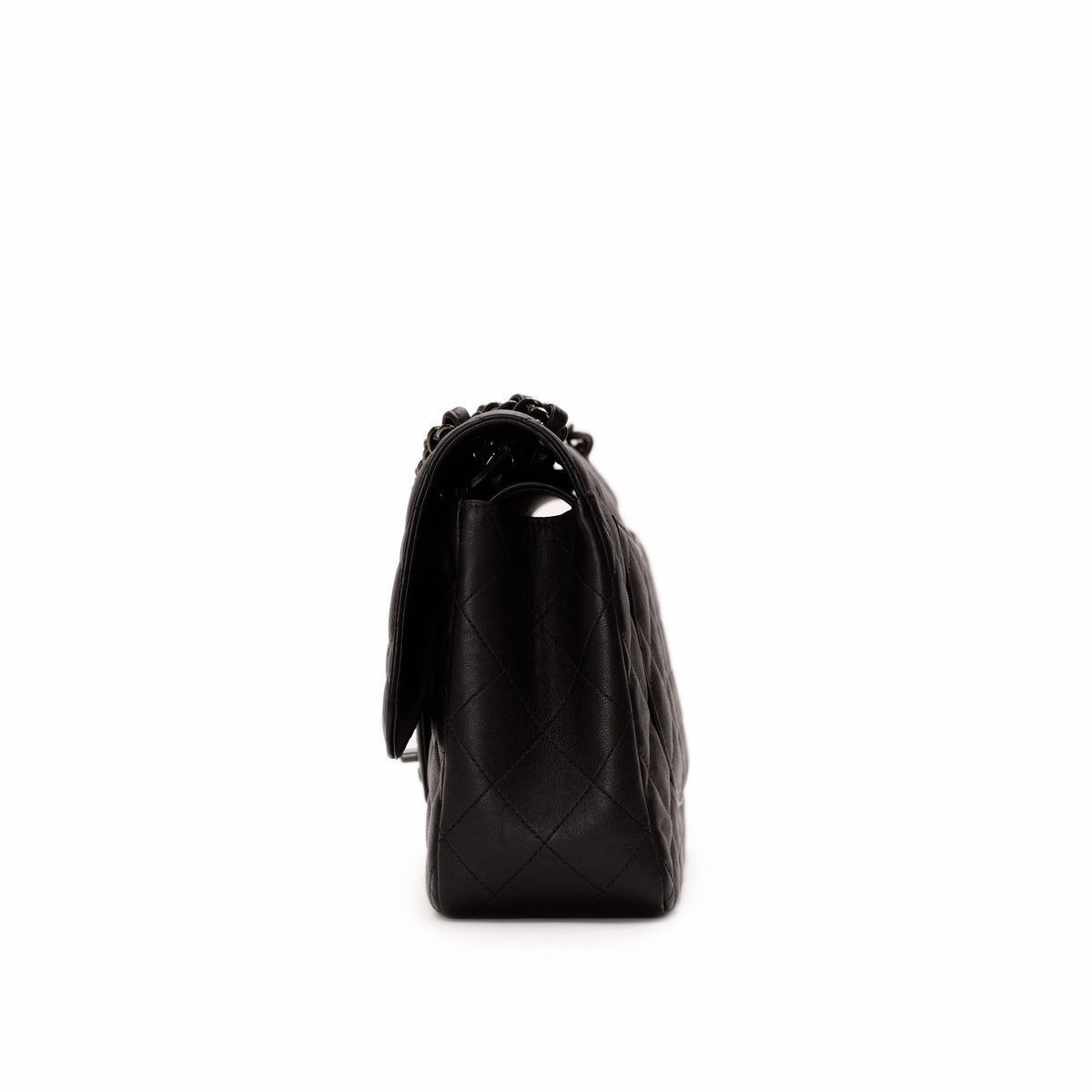Side view of a black quilted leather Chanel handbag with chain strap. curated Pre-loved Luxury by Myluxe in Helsinki.
