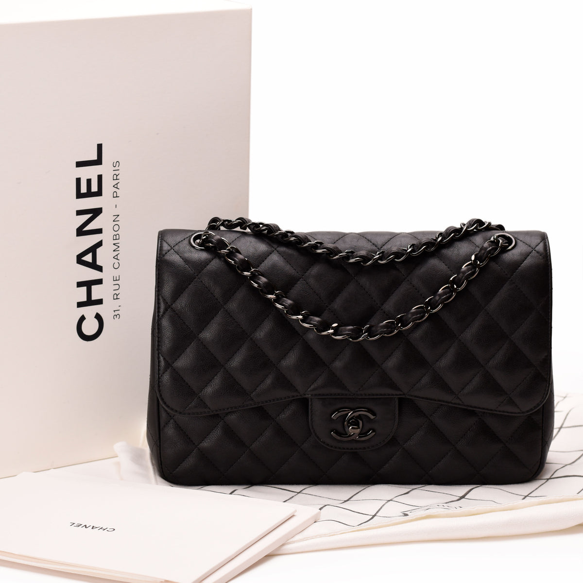 Black quilted lambskin Chanel flap bag with silver-tone chain strap. curated Pre-loved Luxury by Myluxe in Helsinki.