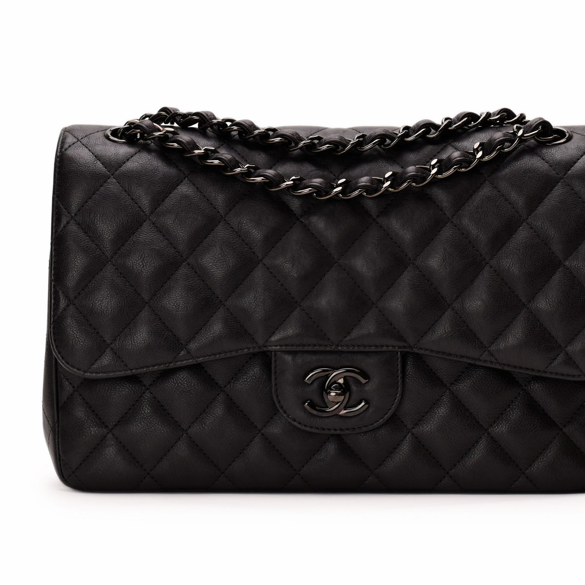 Black quilted leather Chanel handbag with silver chain strap and logo, curated Pre-loved Luxury by Myluxe in Helsinki.