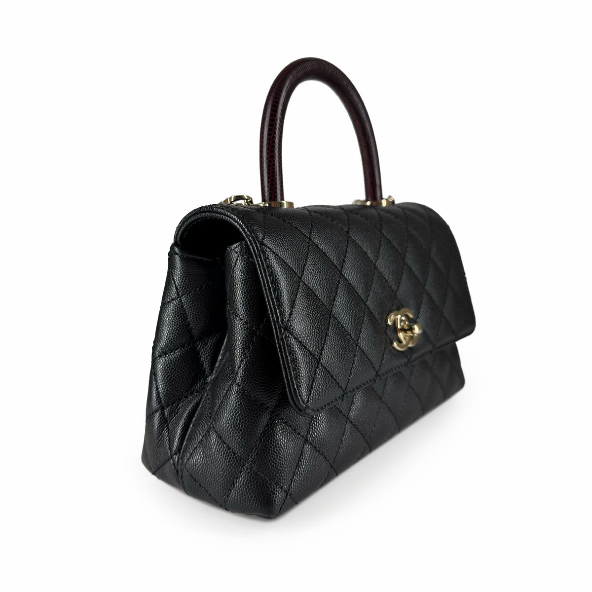 Black quilted leather Chanel handbag with a dark burgundy top handle, curated Pre-loved Luxury by Myluxe in Helsinki.