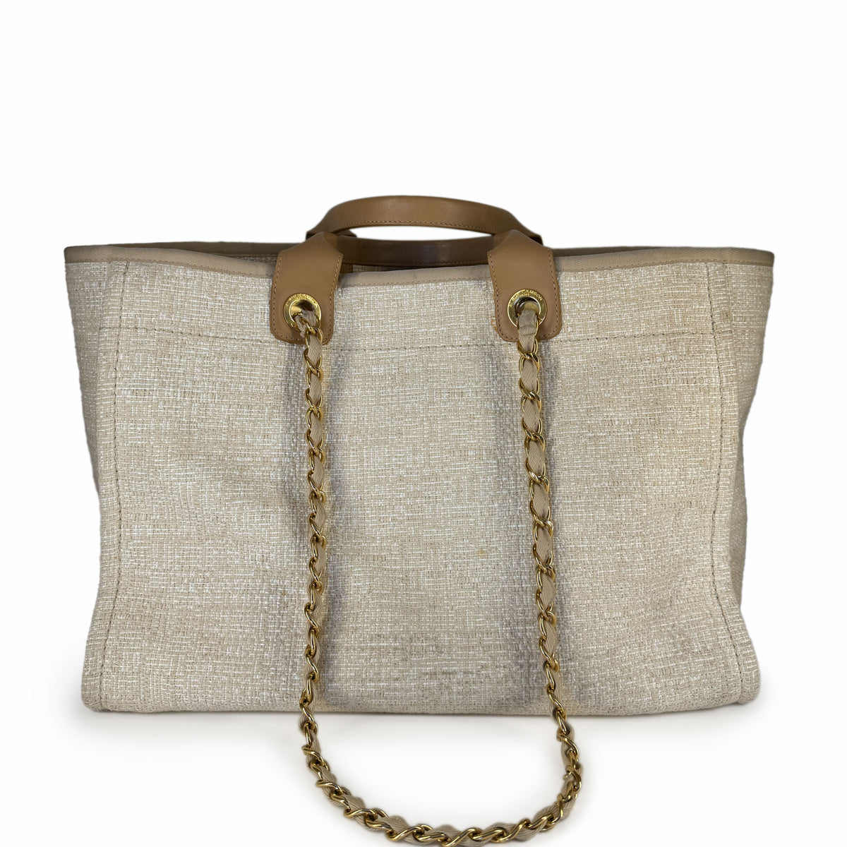 Tan leather handle and gold chain strap on a beige woven tote bag, curated Pre-loved Luxury by Myluxe in Helsinki.