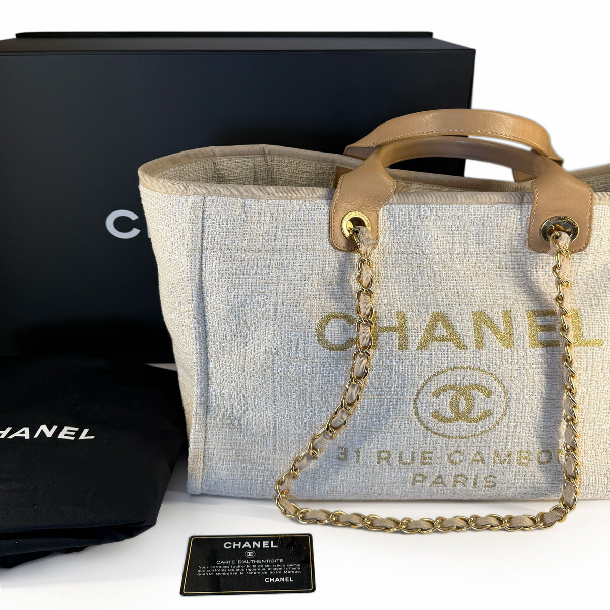 Chanel canvas tote bag with tan leather handles and gold chain strap, curated Pre-loved Luxury by Myluxe in Helsinki.