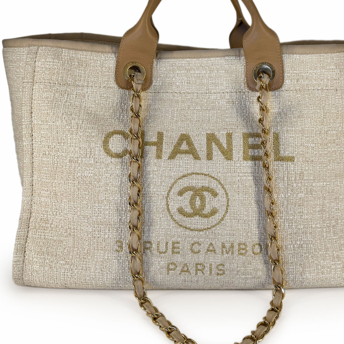Beige canvas Chanel tote bag with gold chain strap and leather handles, curated Pre-loved Luxury by Myluxe in Helsinki.