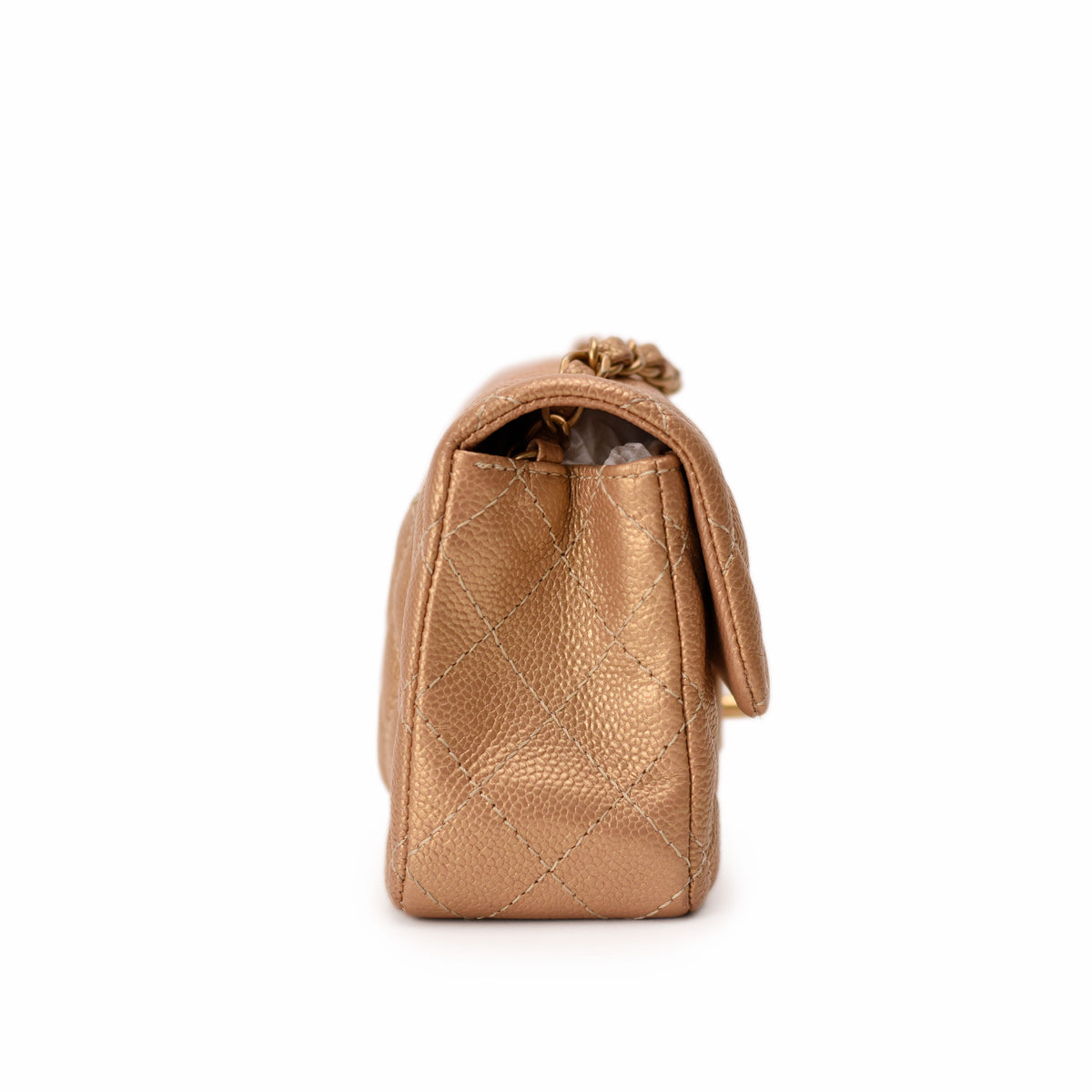 Gold quilted leather Chanel mini bag, side view. curated Pre-loved Luxury by Myluxe in Helsinki.