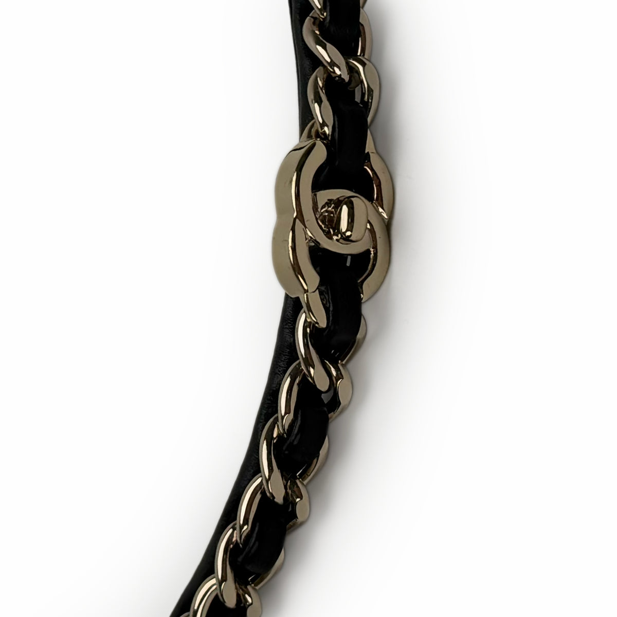Gold-tone Chanel interlocking CC chain strap on black leather, curated Pre-loved Luxury by Myluxe in Helsinki.