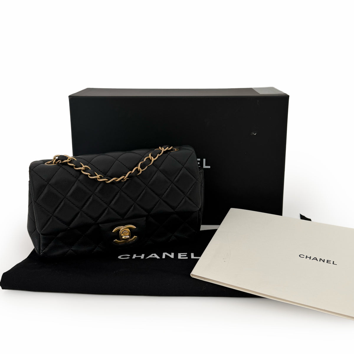Black quilted silk Chanel flap bag with gold chain strap, curated Pre-loved Luxury by Myluxe in Helsinki.