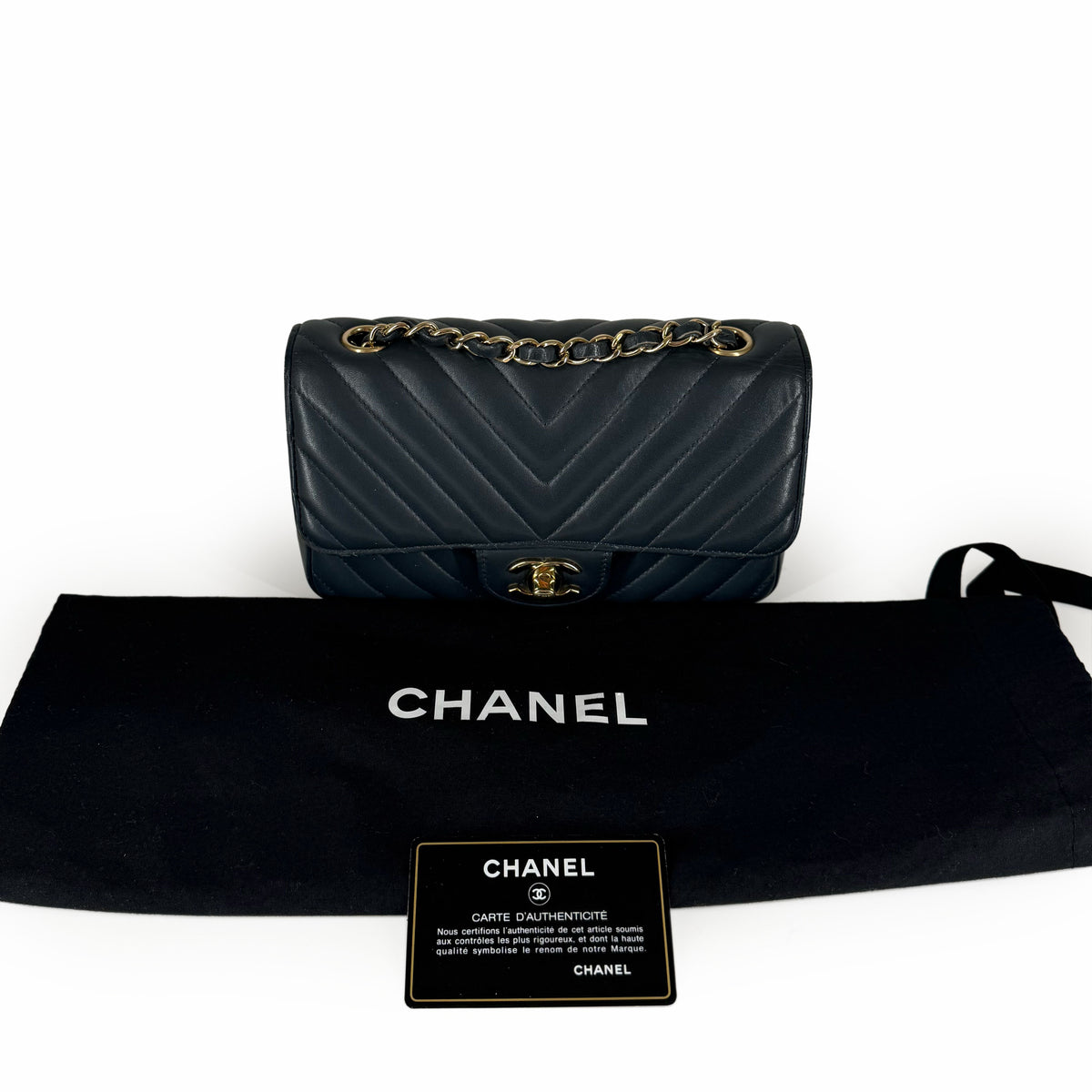 Black quilted leather Chanel flap bag with gold chain strap and authenticity card, curated Pre-loved Luxury by Myluxe in Helsinki.