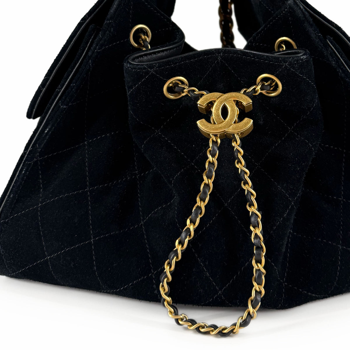 Black quilted suede Chanel bucket bag with gold-tone chain detail, curated Pre-loved Luxury by Myluxe in Helsinki.