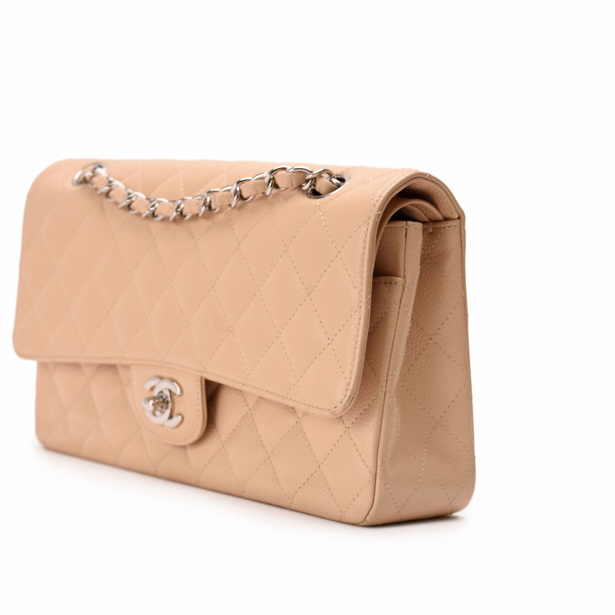 Beige quilted leather Chanel flap bag with silver chain strap, curated Pre-loved Luxury by Myluxe in Helsinki.