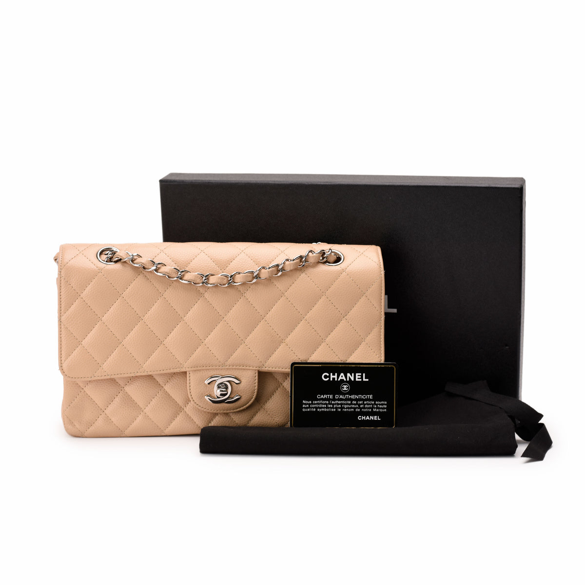 Beige quilted leather Chanel flap bag with silver chain strap, curated Pre-loved Luxury by Myluxe in Helsinki.
