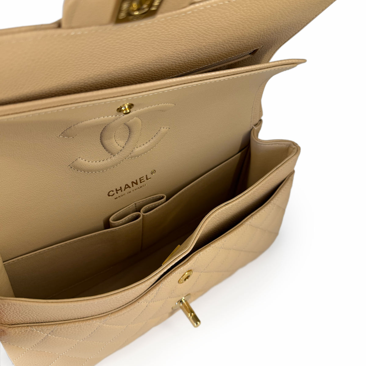 Interior of a beige quilted Chanel leather handbag with gold hardware, curated Pre-loved Luxury by Myluxe in Helsinki.