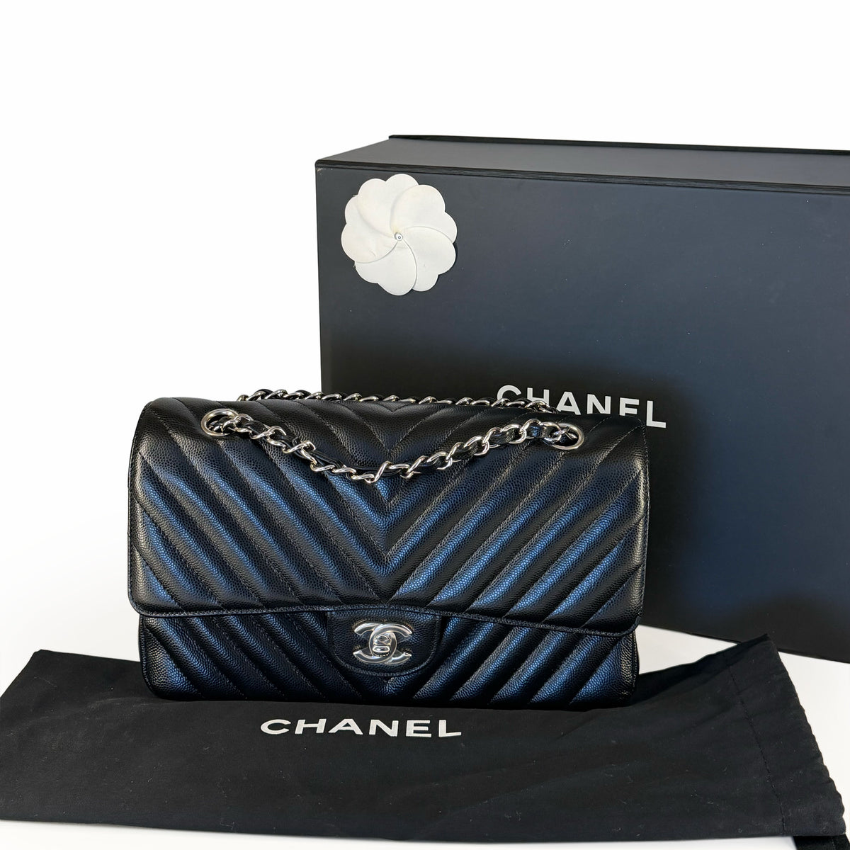 Black chevron quilted Chanel flap bag with silver chain strap, curated Pre-loved Luxury by Myluxe in Helsinki.
