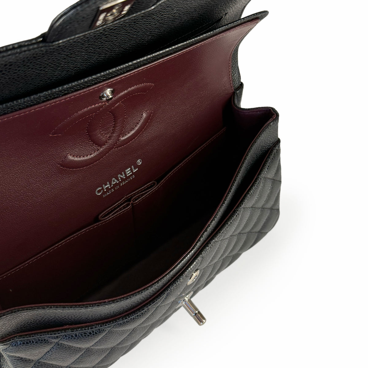 Black quilted leather Chanel flap bag with burgundy interior, curated Pre-loved Luxury by Myluxe in Helsinki.