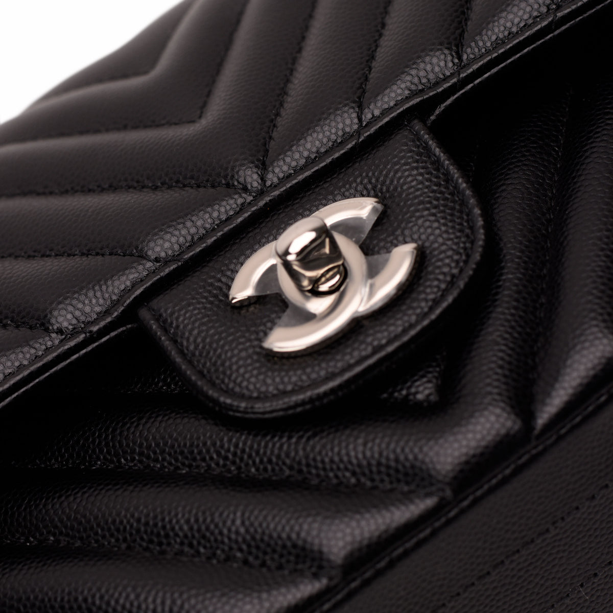 Black caviar leather Chanel flap bag with silver-tone CC interlocking logo, curated Pre-loved Luxury by Myluxe in Helsinki.
