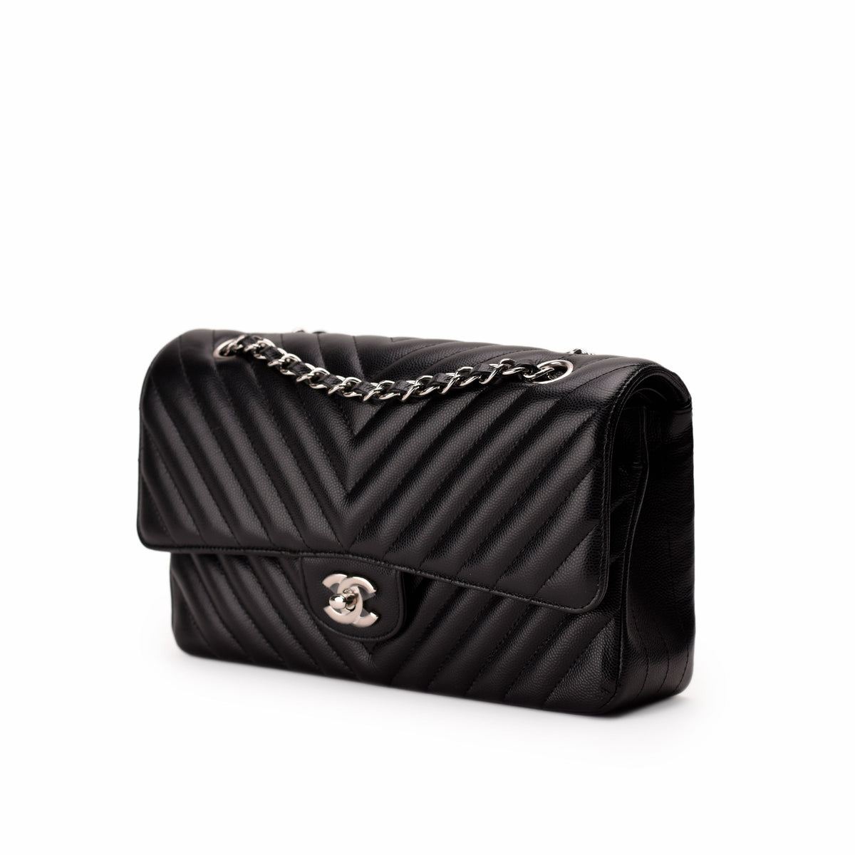 Black chevron quilted leather Chanel flap bag with silver chain strap, curated Pre-loved Luxury by Myluxe in Helsinki.