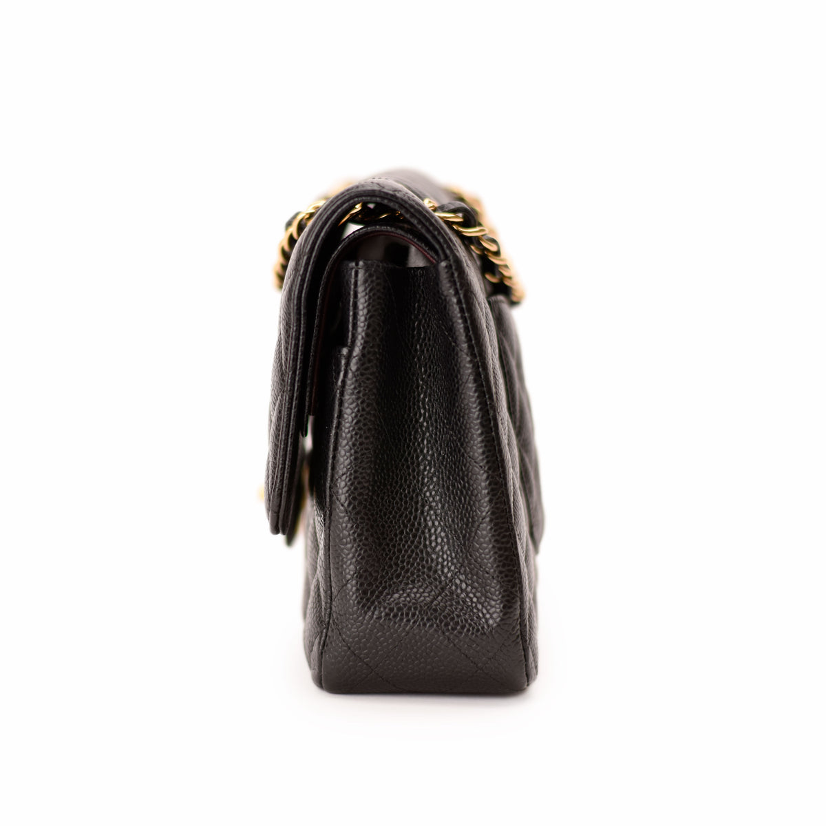 Side view of a black quilted leather Chanel handbag with a gold chain strap, curated Pre-loved Luxury by Myluxe in Helsinki.