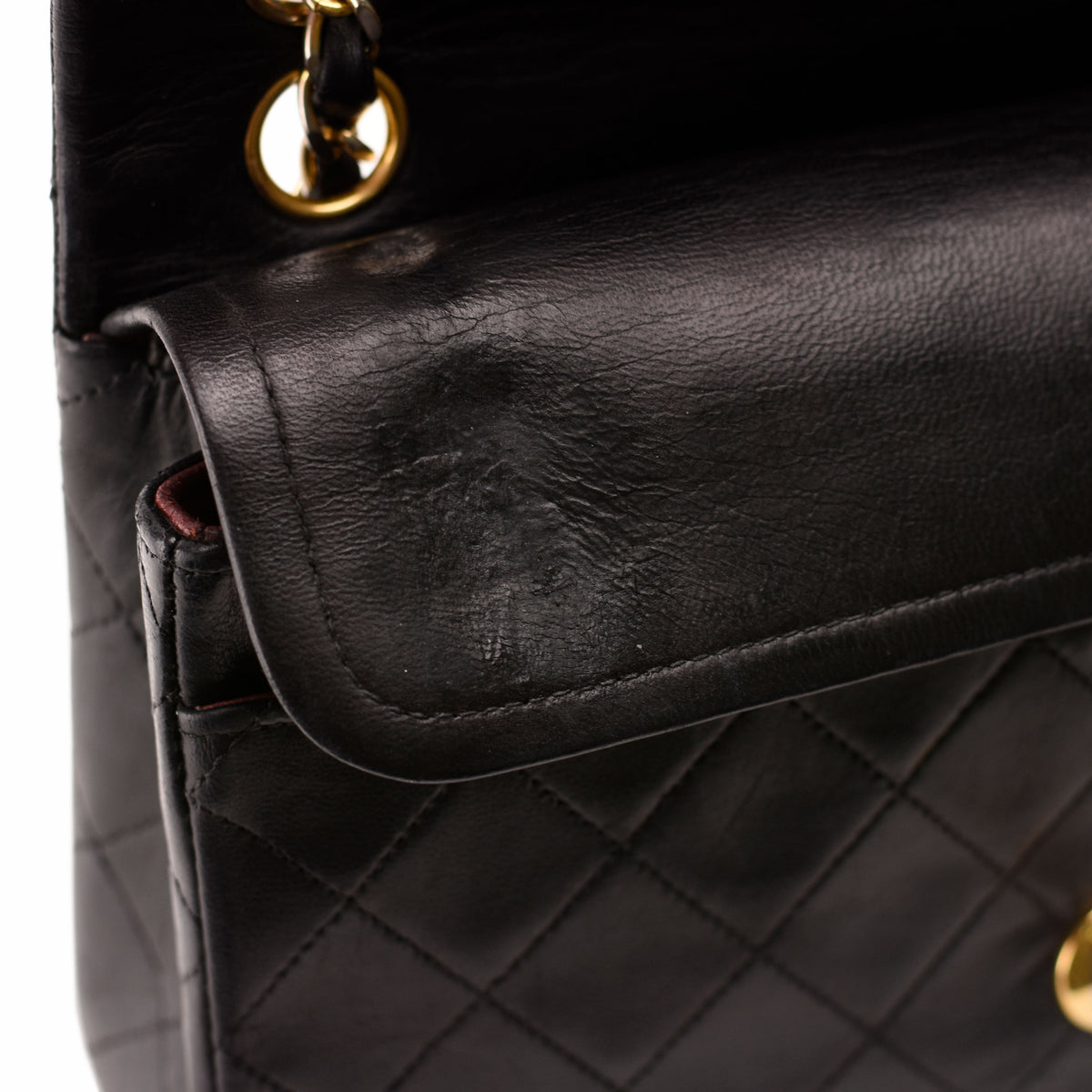 Close-up of black quilted leather Chanel handbag with gold-tone chain, curated Pre-loved Luxury by Myluxe in Helsinki.
