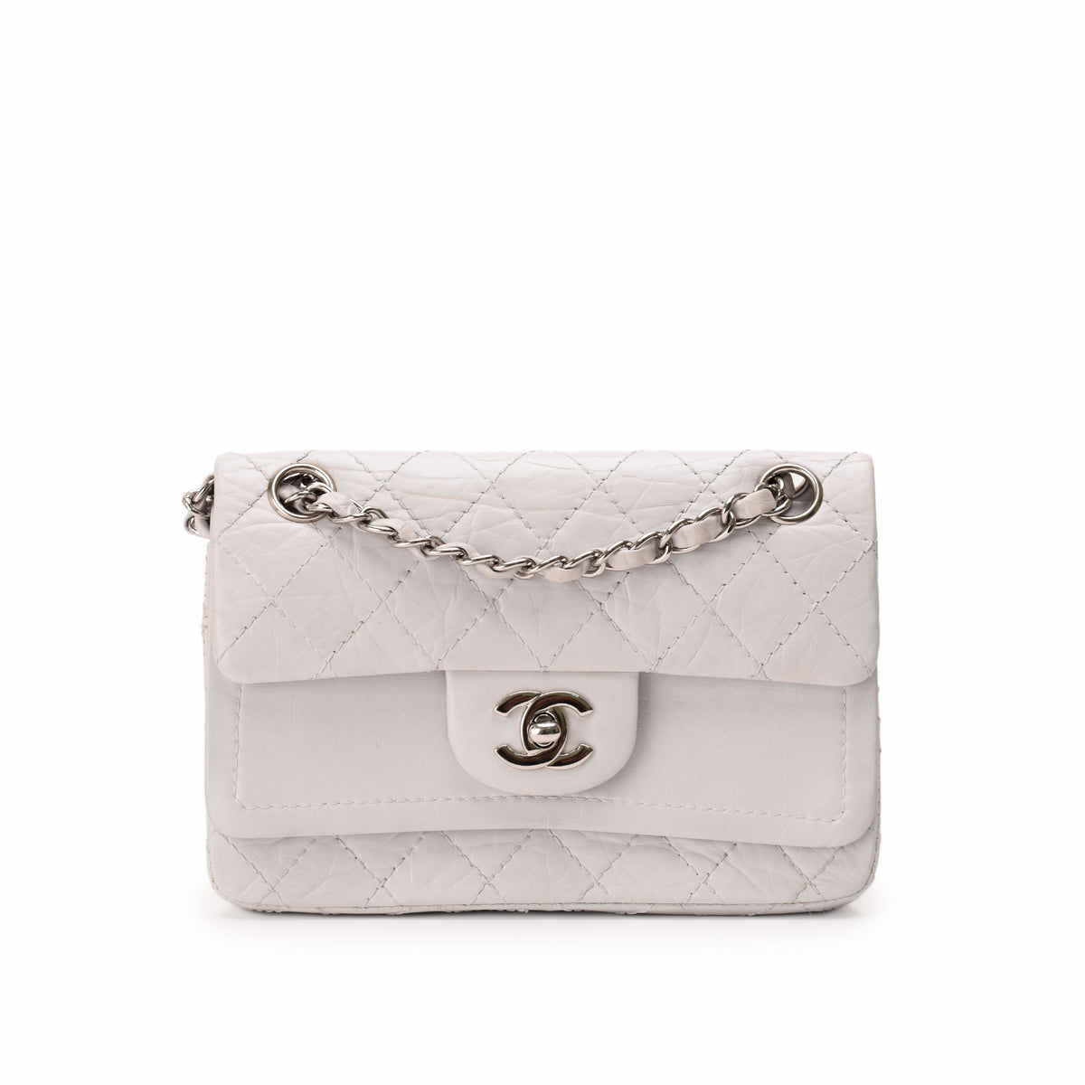 White quilted leather Chanel flap bag with silver chain strap, curated Pre-loved Luxury by Myluxe in Helsinki.
