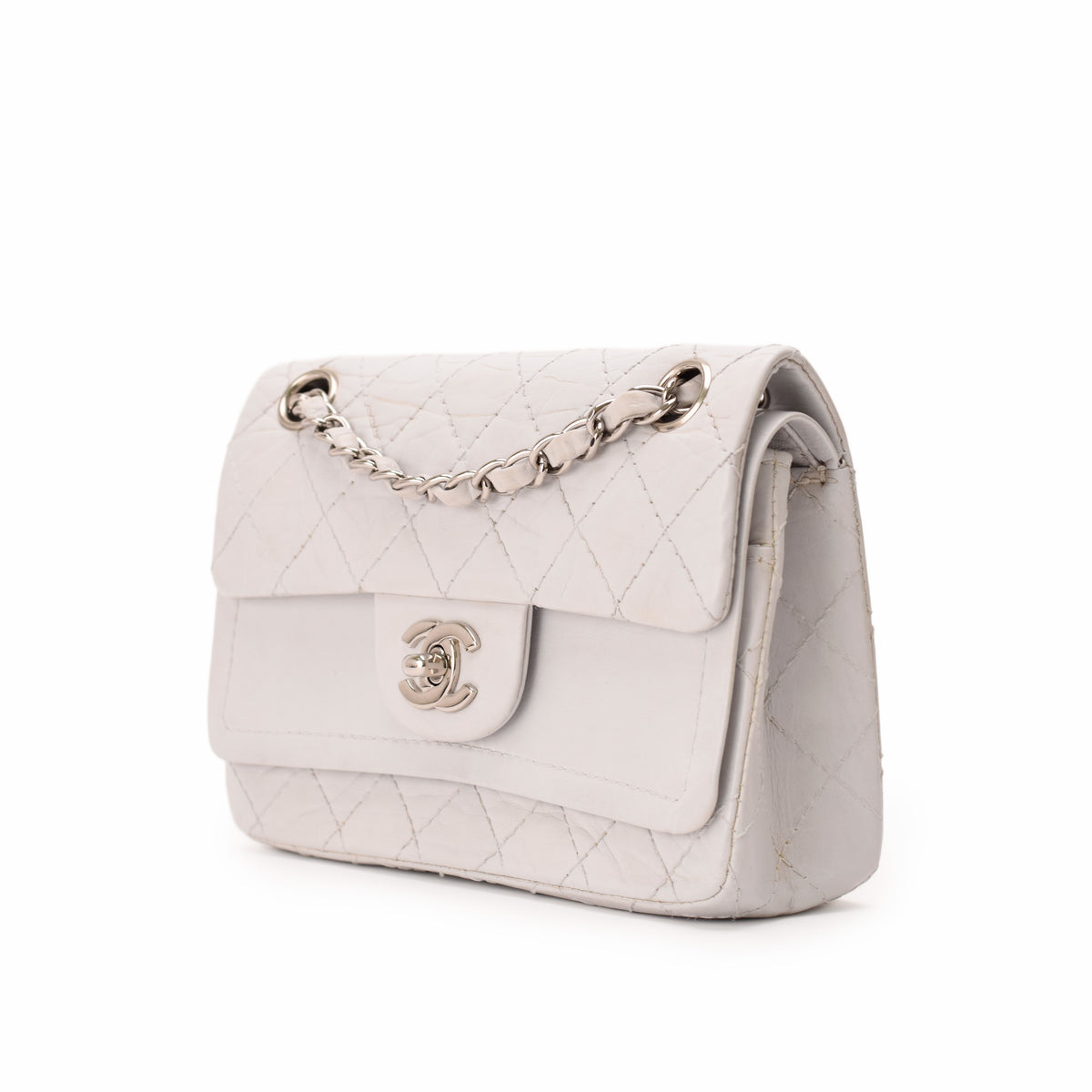 White quilted leather Chanel flap bag with silver chain strap, curated Pre-loved Luxury by Myluxe in Helsinki.