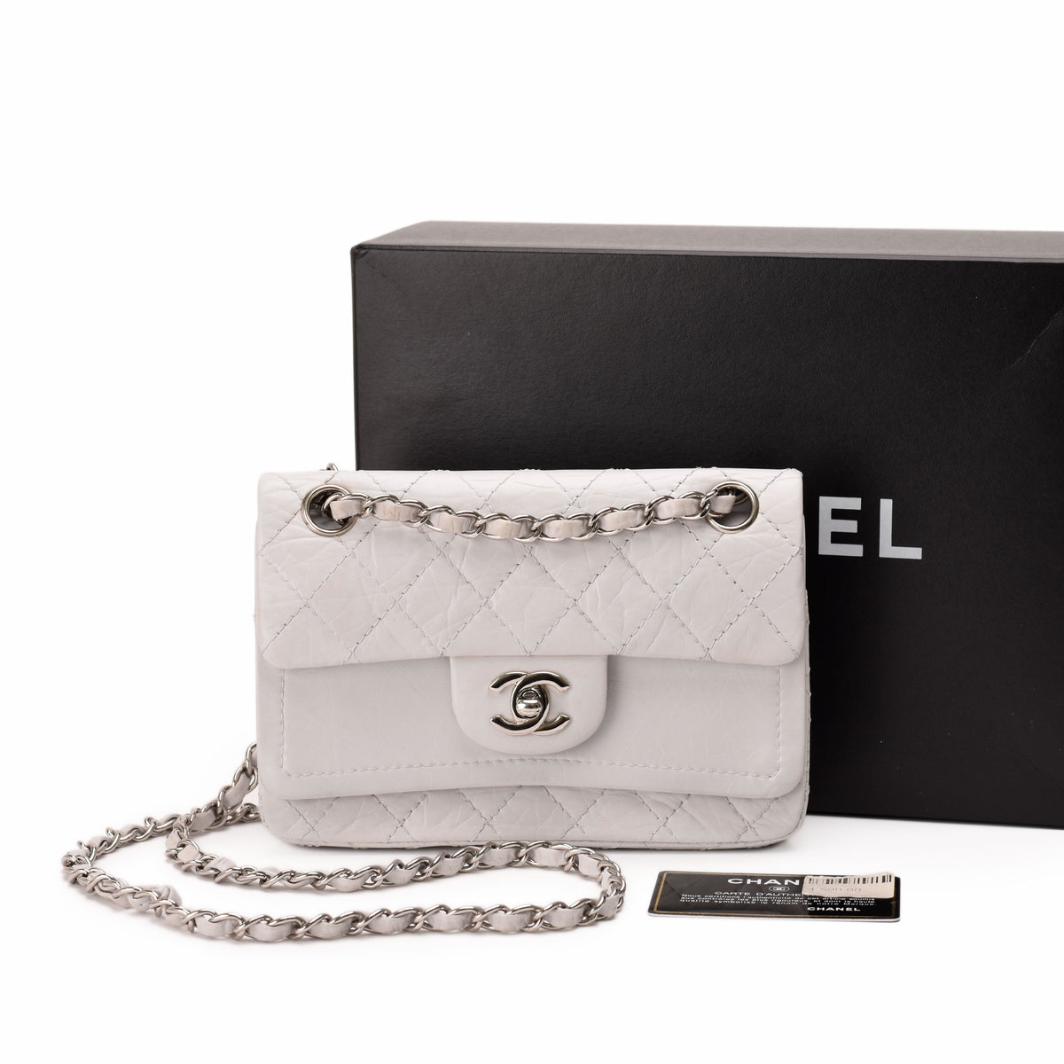 White quilted lambskin Chanel flap bag with silver chain strap, curated Pre-loved Luxury by Myluxe in Helsinki.
