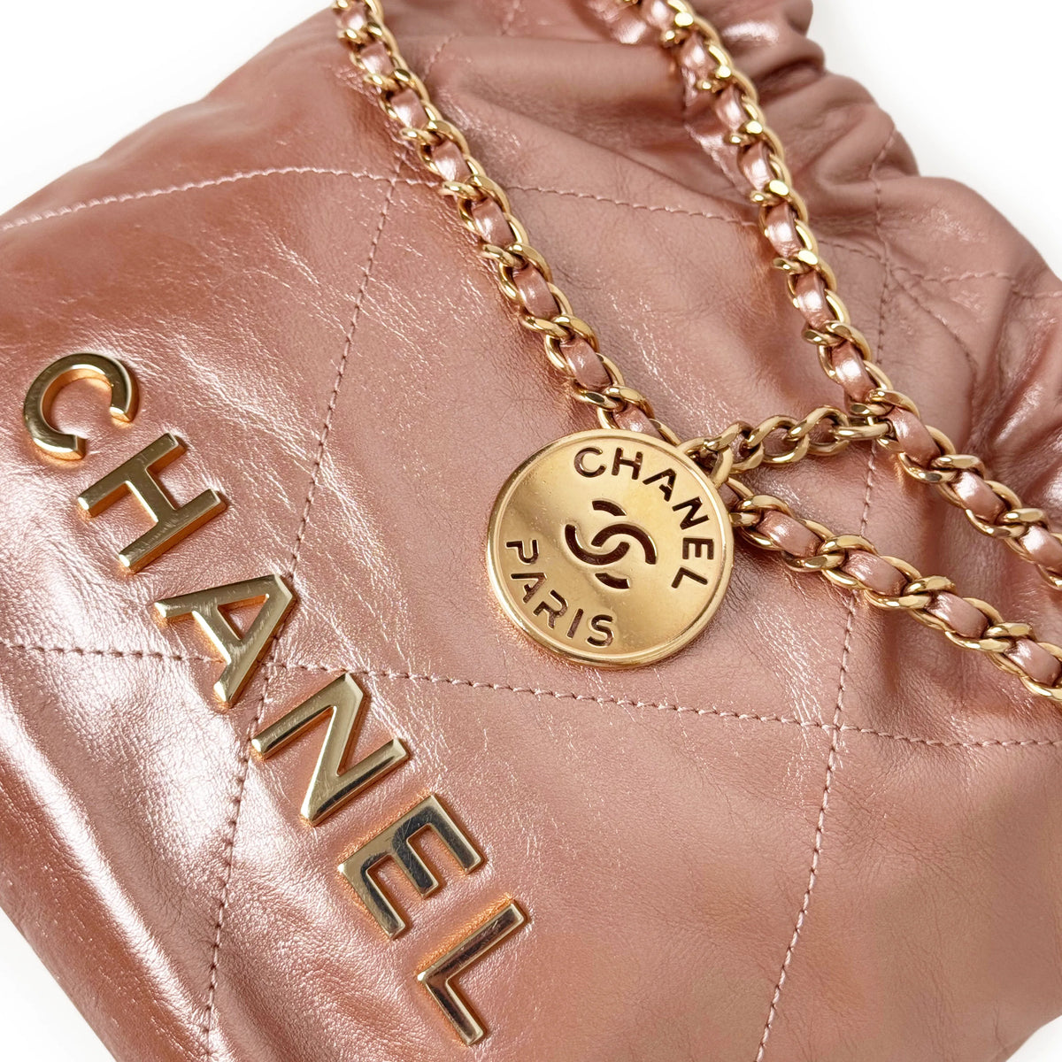 Pink quilted leather Chanel drawstring pouch with gold chain strap, curated Pre-loved Luxury by Myluxe in Helsinki.