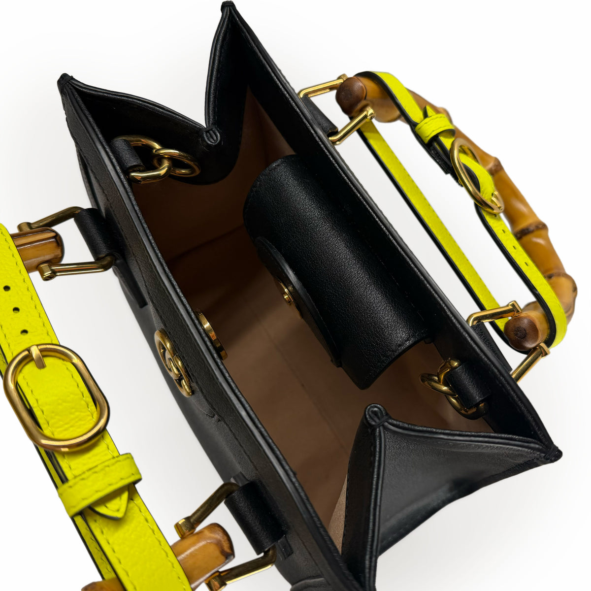 Interior view of a black leather handbag with yellow accents and bamboo handles, curated Pre-loved Luxury by Myluxe in Helsinki.