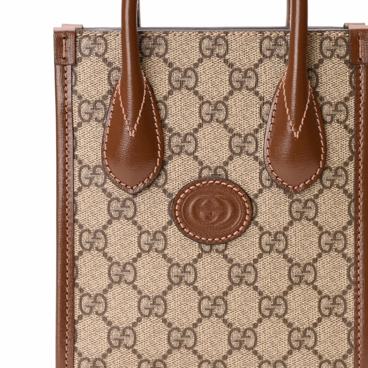 Gucci Interlocking G Mini Tote Bag in GG Supreme Canvas with leather handles and gold-tone hardware, stylish and compact bag.