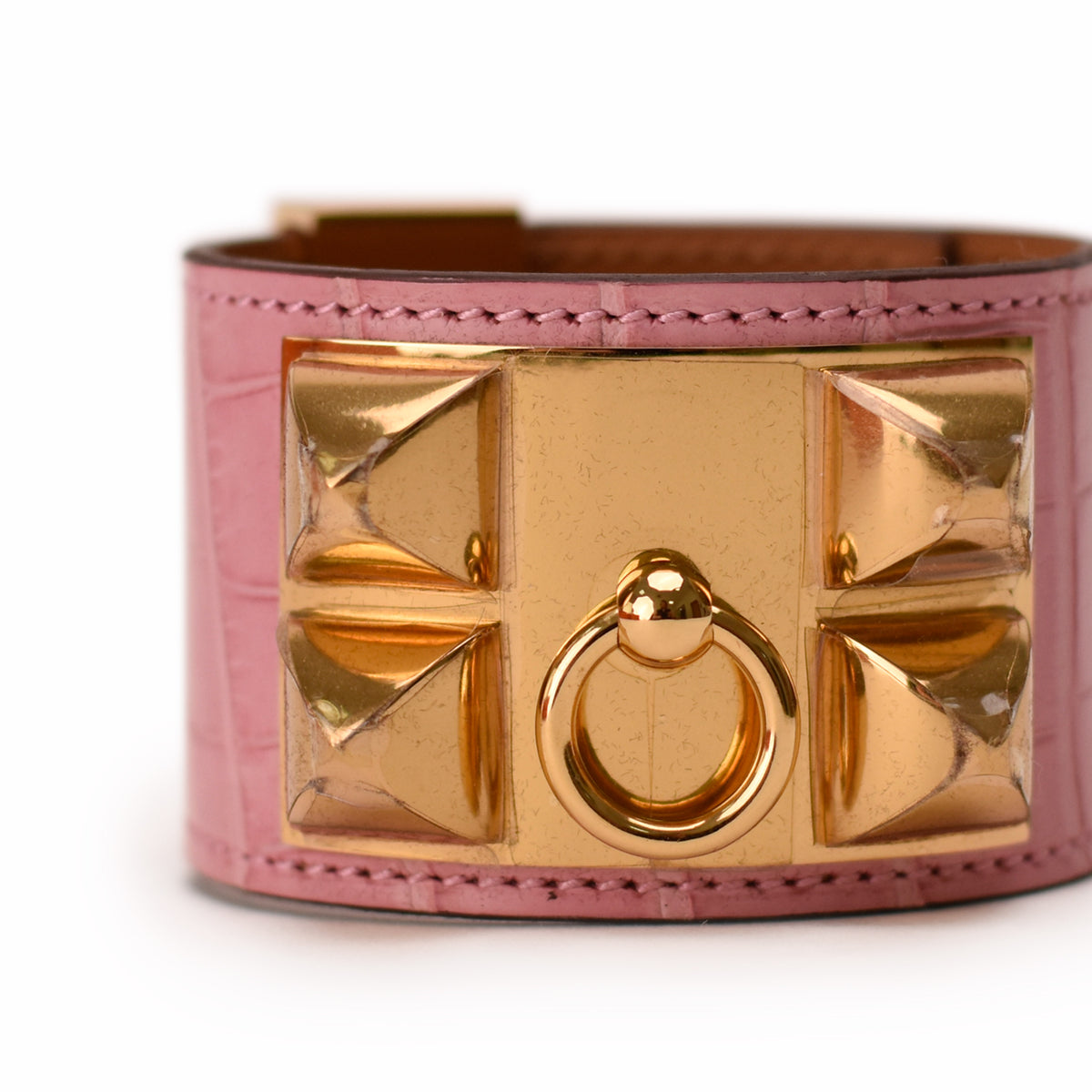 Pink crocodile-embossed leather cuff bracelet with gold-tone pyramid studs and ring detail. curated Pre-loved Luxury by Myluxe in Helsinki.