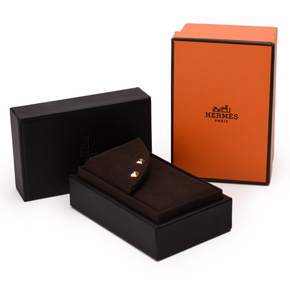 Hermès gold-tone stud earrings in a black velvet jewelry box, curated Pre-loved Luxury by Myluxe in Helsinki.