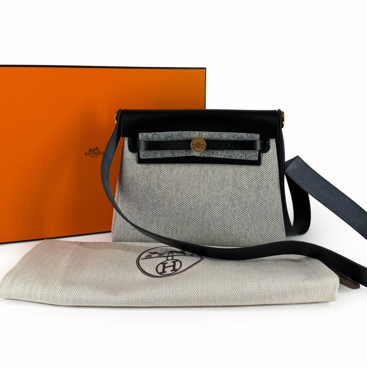 Hermès crossbody bag in grey canvas with black leather trim, curated Pre-loved Luxury by Myluxe in Helsinki.