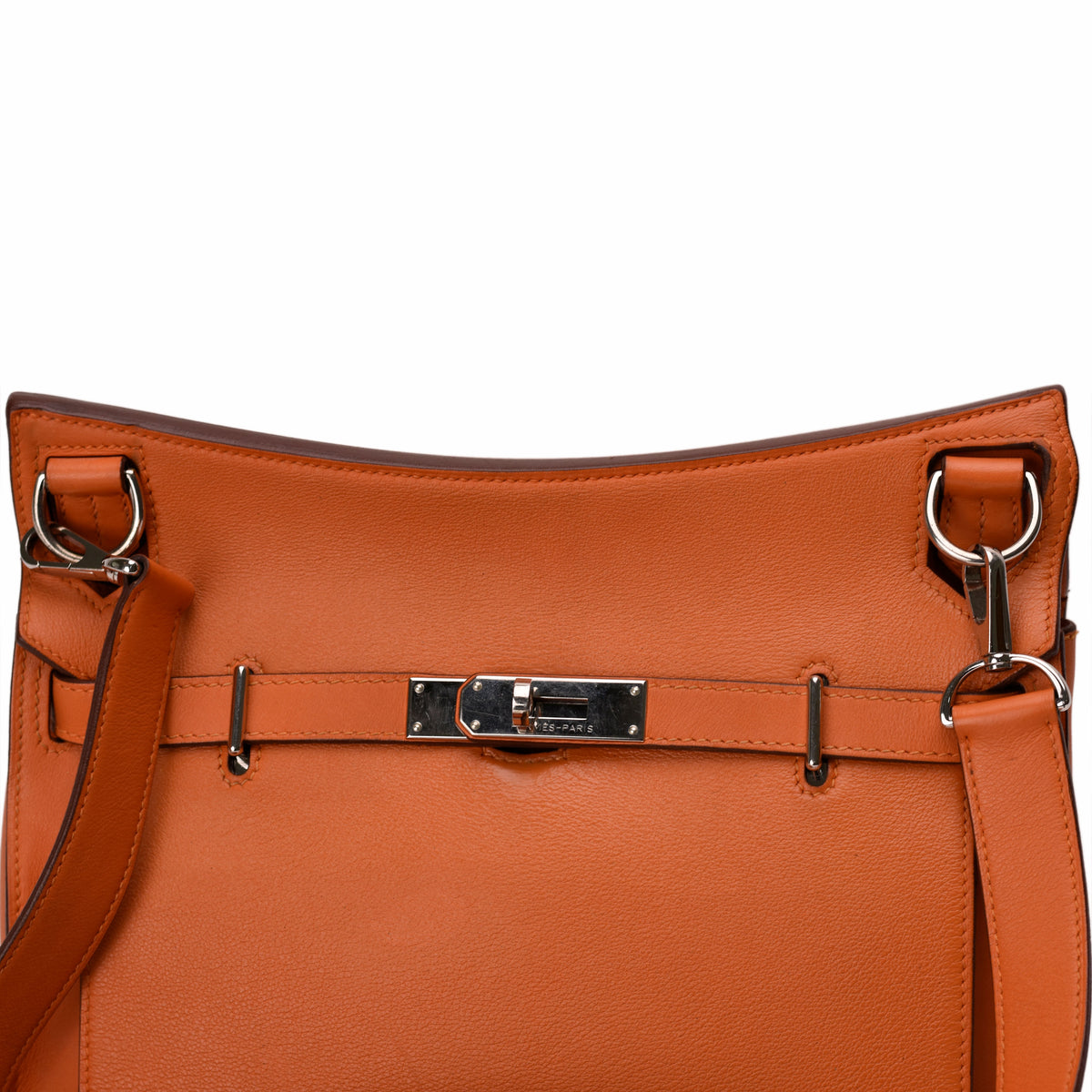Close-up of an orange leather Hermès handbag with silver-tone hardware. curated Pre-loved Luxury by Myluxe in Helsinki.